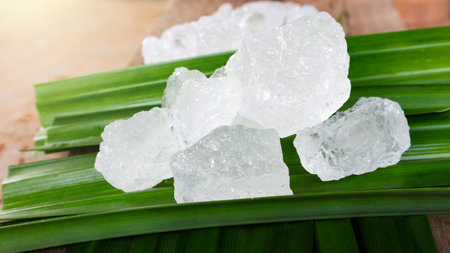 Crystal clear alum cubes or Potassium alum on green leaf. Chemical compound substance. Concept for...