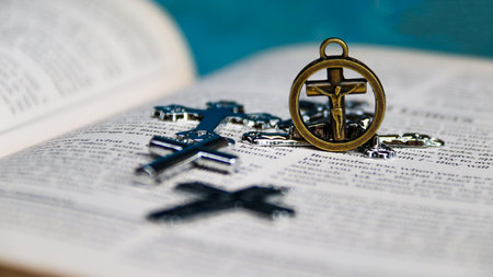 Closeup of a Christian cross on an open bible. Selective focus.