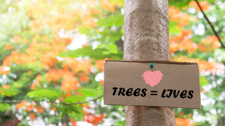 Brown paper sign on a tree trunk with the text trees equal lives, concept for animals and environment saving and preservationの写真素材