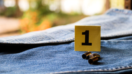 Pistol bullet shells on blur blue jeans and number one display in background, concept for criminal and investigation. soft focusの写真素材