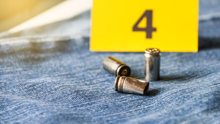 Pistol bullet shells on blur blue jeans and number four display in background, concept for criminal and investigation. soft focusの写真素材