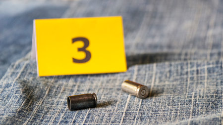 Pistol bullet shells on blur blue jeans and number three display in background, concept for criminal and investigation. soft focusの写真素材