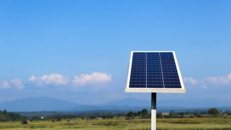 Photovoltaic panel on blurred  field in background, concept for using solar cell panel to power water pump to agriculture areaの写真素材