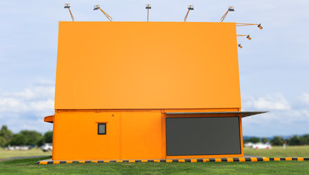 Yellow building and copy space with blurred grass field and mountains blue sky views in backgroundの写真素材