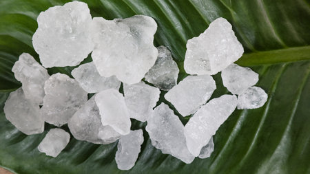 White alum cubes or Potassium alum on green leaf chemical compound substance concept of beauty spa and underarm treatment industrialの写真素材