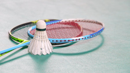 White badminton shuttlecocks and badminton rackets on green floor indoor badminton courtの写真素材