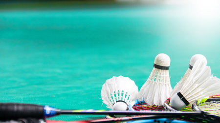 White badminton shuttlecocks and badminton rackets on green floor indoor badminton courtの写真素材