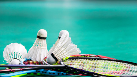 White badminton shuttlecocks and badminton rackets on green floor indoor badminton courtの写真素材