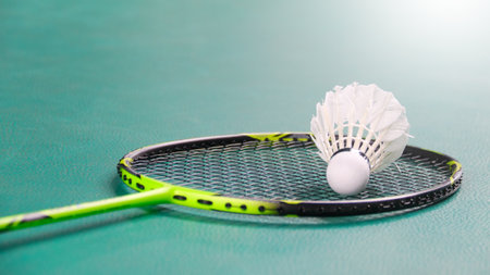 White badminton shuttlecocks and badminton rackets on green floor indoor badminton courtの写真素材