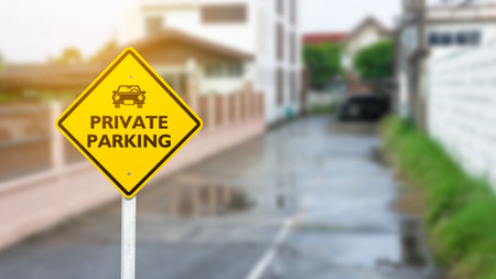 Car shape printed on yellow parking sign with text private parking in a private parking spaceの写真素材