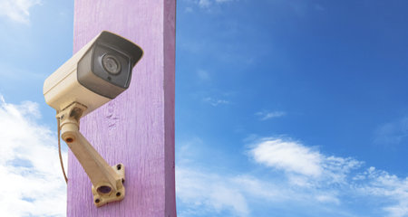 Traditional surveillance camera installed at the house to provide security for the resident on blue sky backgroundの写真素材