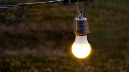 A vintage light bulb glows beautifully at night, casting a warm, soft light that creates a cozy and...