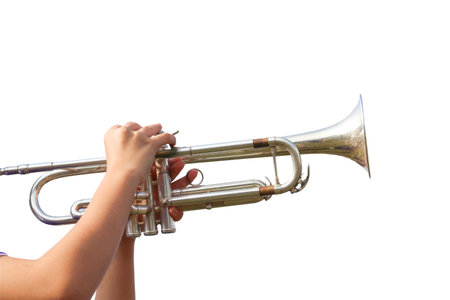 A cut-out of hands playing a trumpet on a white background with clipping paths. The focus is on the musician's hands and the instrument, highlighting the skill and musical expression.の写真素材