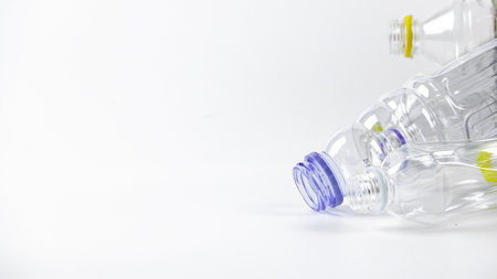 Clear plastic bottles on a white surface, awaiting recycling. Highlights the importance of recycling waste, loving the Earth, and conserving natural resources.の写真素材