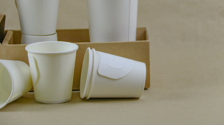 White paper coffee cup, used paper, and cardboard box on a brown surface, awaiting recycling. Promotes recycling waste, saving the Earth, and conserving natural resources.の写真素材