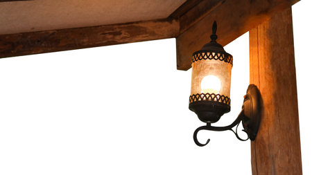 Image of an antique lamp covered in dust and cobwebs, mounted on an old dark brown wooden plank wall in old antique houseの写真素材