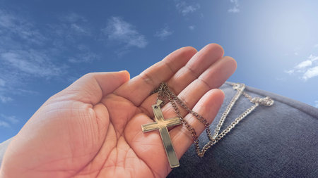 A cross resting in an open palm, symbolizing the spreading of Jesus Christ's love to all, a powerful representation of faith and the mission to share His teachings with the world.の写真素材