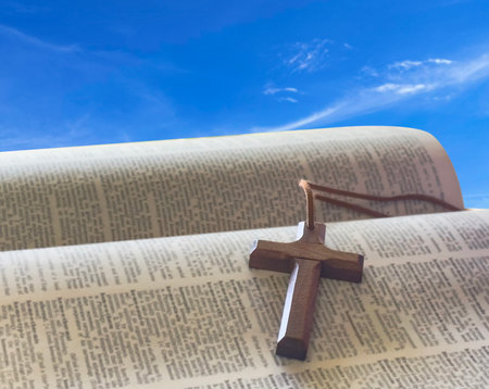 A brown wooden cross resting in an open palm, symbolizing the spreading of Jesus Christ's love to all, a powerful representation of faith and the mission to share His teachings with the world.の写真素材