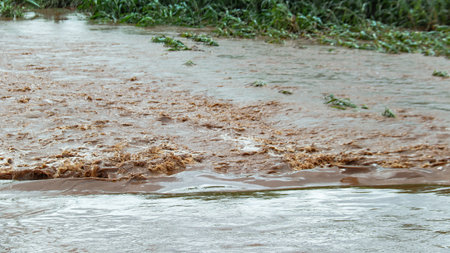 An image of thick red floodwater waves, showcasing the turbulent and ominous nature of the flood as it moves through the area.の写真素材