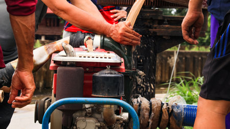 An image of a water pump being prepared to drain floodwater from a community, capturing the efforts to combat the effects of severe flooding.の写真素材