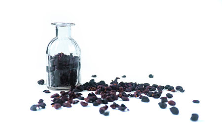 Dark, dried coffee bean husks on a white background, highlighting the rough texture and deep color, suitable for themes related to coffee production and processing.の写真素材