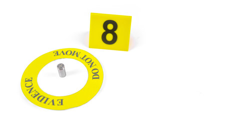 A spent bullet casing placed within a yellow circle, labeled with the text Evidence, Do Not Move, with a blurred number 8 tag, set against a white background, concept of crime investigation.の写真素材