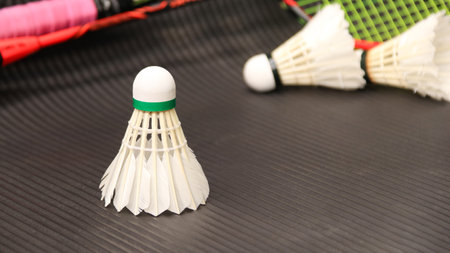 White badminton shuttlecocks and badminton rackets on dark backgroundの写真素材
