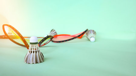 Dark badminton shuttle cock and broken frame badminton racket on green background, soft and selective focus. concept of badminton sport and competition.の写真素材