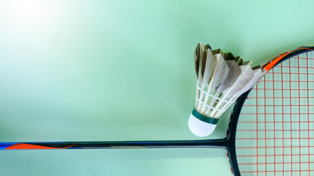 White badminton shuttlecocks and badminton rackets on green background concept of badminton lovers and competition.の写真素材