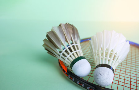 Badminton shuttlecocks with rackets on a green background symbolizing the spirit of exercise and global competition the essence of athleticism and the pursuit of excellence in the sport.の写真素材