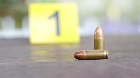 9 mm pistol bullet lying on dark wooden bench with blur number 1 sign on blur background. Concepts of criminal investigations and shooting sport.の写真素材