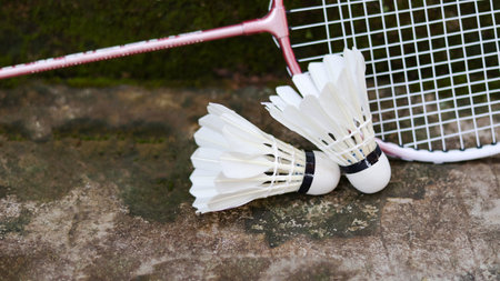White badminton shuttlecocks and badminton rackets on dark background to enhance doing exercise.の写真素材