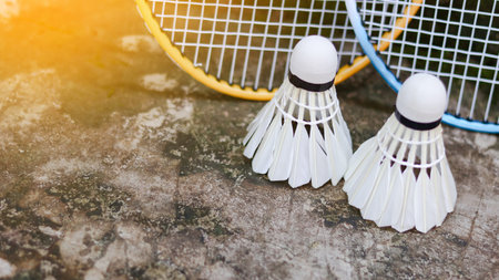 White badminton shuttlecocks and badminton rackets on dark background.の写真素材