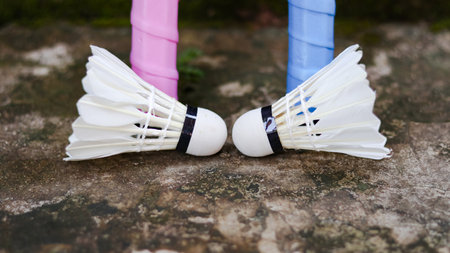 White badminton shuttlecocks and badminton rackets on dark background to enhance doing exercise.の写真素材