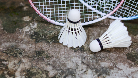 White badminton shuttlecocks and badminton rackets on dark background to enhance doing exercise.の写真素材