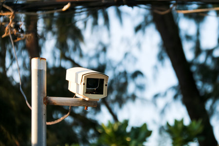An old yet reliable CCTV camera mounted outdoors, exposed to sun and rain over the years, standing guard to ensure security for homes. A symbol of safety and modern surveillance technology.の写真素材