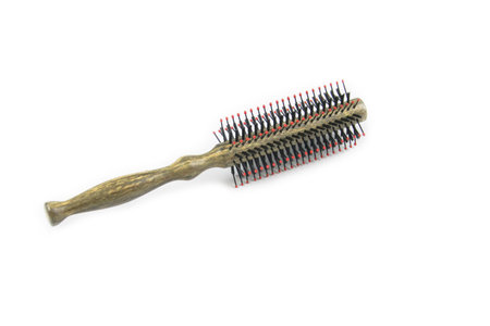 A classic hairbrush with metal bristles and a wooden handle is cut out with clipping paths on a white background.の写真素材