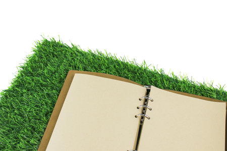 An open blank notebook resting on artificial grass, copy space for creative writing, or note taking.の写真素材