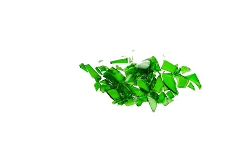 Sharp and jagged pieces of broken green glass cut out on a white background, symbolizing fragility and caution.の写真素材