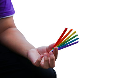 Rainbow colored ice cream sticks held in hand, symbolizing LGBTQ+ pride, diversity, and inclusion. A...