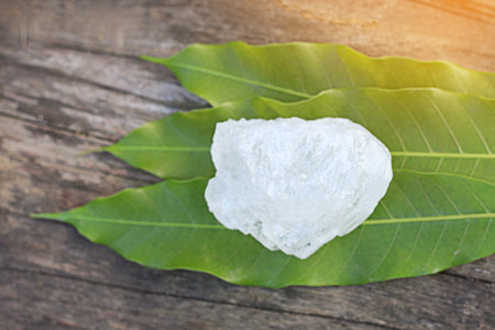Crystal clear alum cubes or Potassium alum in on green leaves chemical compound substance concept...