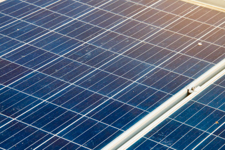Solar panels with visible dirt and dust mounted on a rooftop. Represents the importance of maintenance for sustainable and efficient renewable energy usage.の写真素材