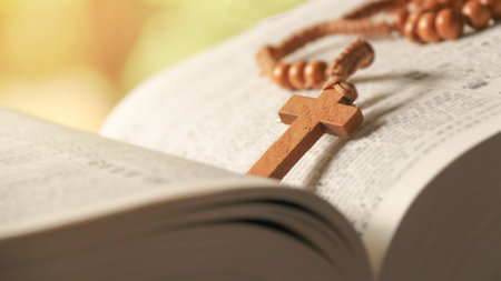 Wooden Christian cross placed on an old vintage book.