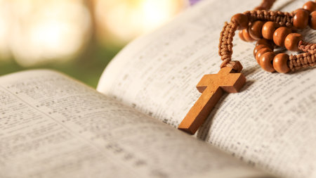Wooden Christian cross placed on an old vintage book.