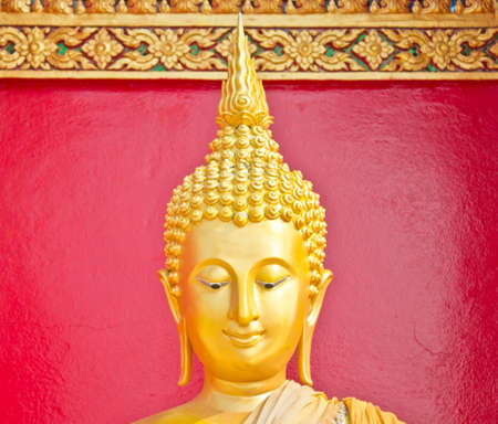 Golden Lord Buddha close up over the red wallの写真素材