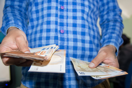 Male hands counting large amount of euro currency cash banknotes, low view