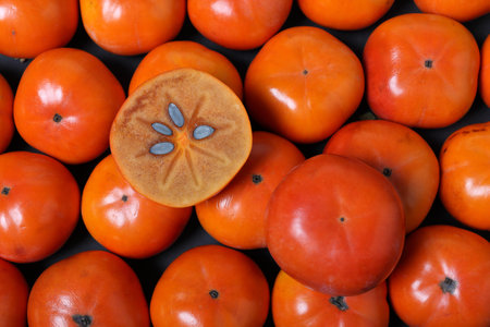 Fresh ripe persimmon fruit on black background. Top view.の写真素材