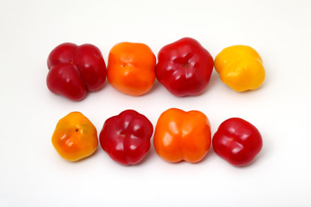 A group of red and yellow peppers isolated on a white background.の写真素材