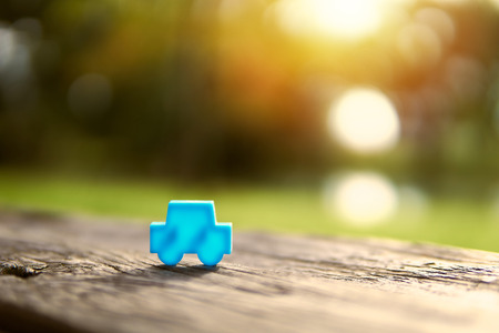 Home and car models placed on wooden boards.The background is the sun sent to the model.Trading or exchanging  in business and real estate.For family happiness.の写真素材
