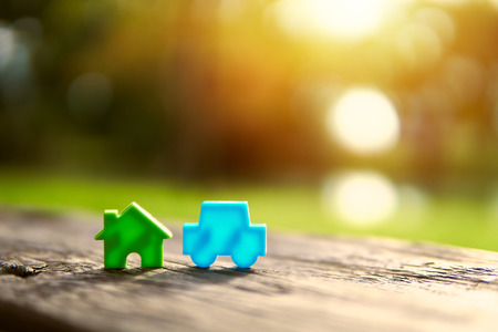 Home and car models placed on wooden boards.The background is the sun sent to the model.Trading or exchanging  in business and real estate.For family happiness.の写真素材